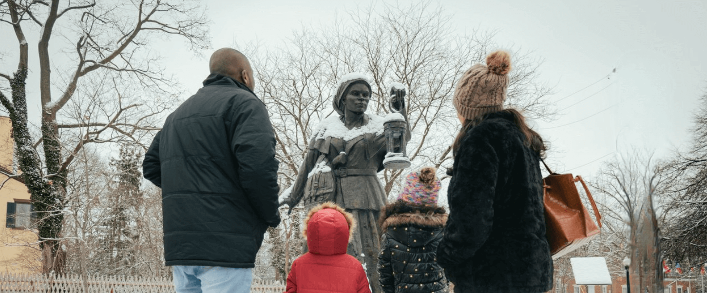 一家人站在平等权利遗产中心院子里的哈丽特·塔布曼铜像前